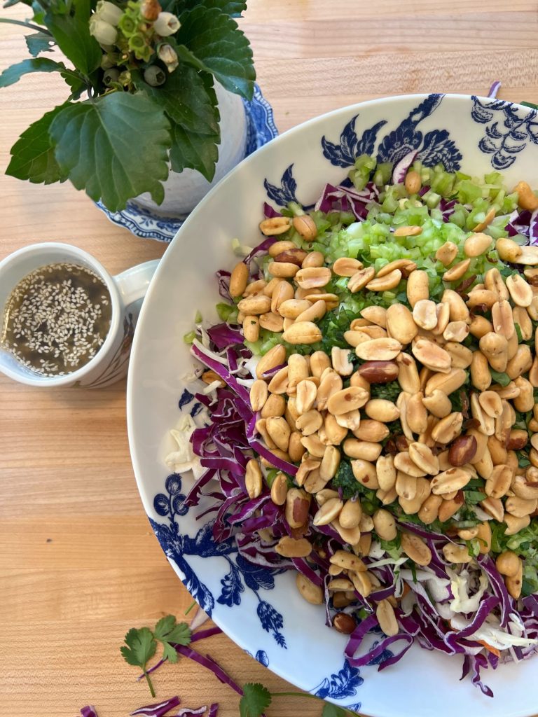 blue and white bowl and a peanut crunchy peanut coleslaw with a vinaigrette dressing.