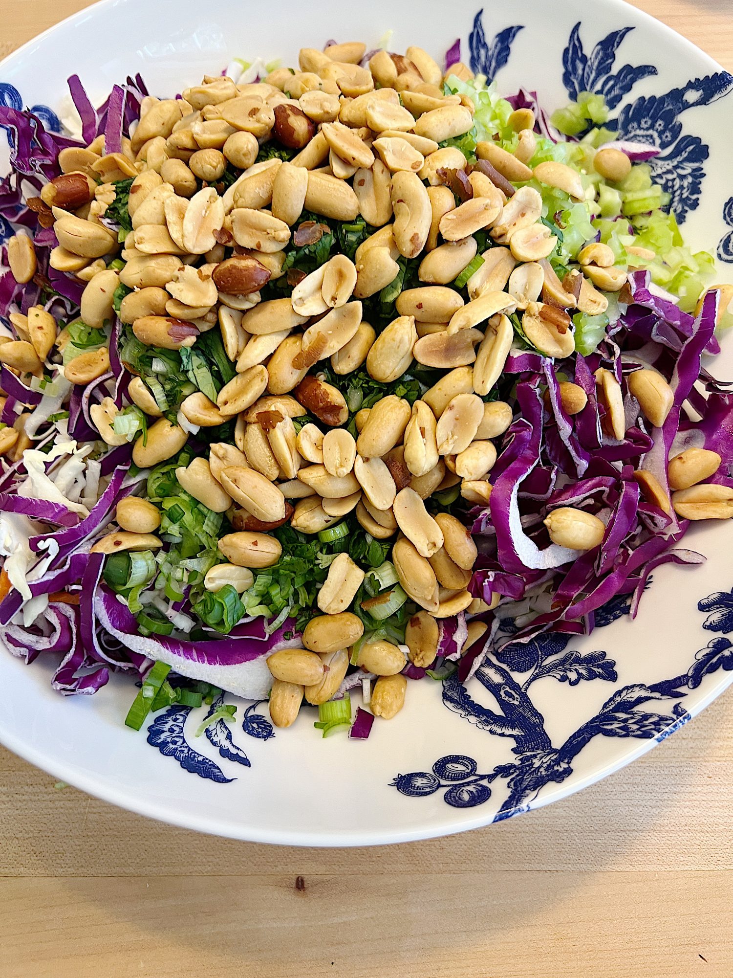 blue and white bowl and a peanut crunchy peanut coleslaw with a vinaigrette dressing.
