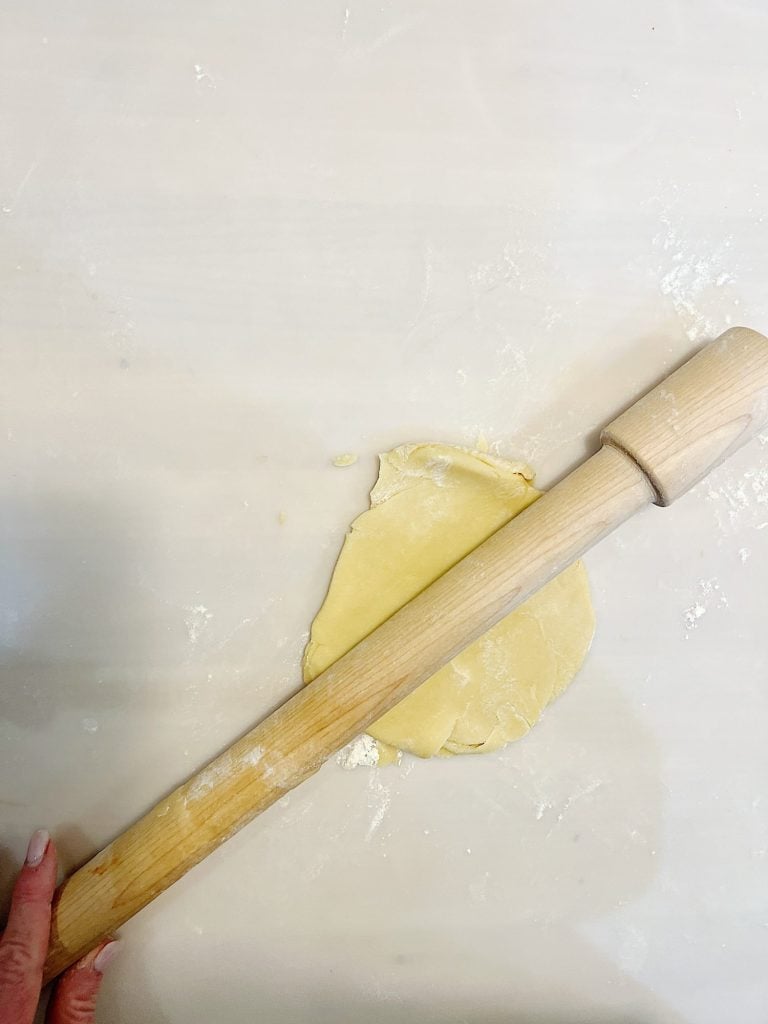 rolling out cookie dough with a wooden rolling pin