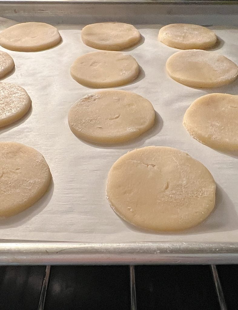 round sugar cookies baking in an oven