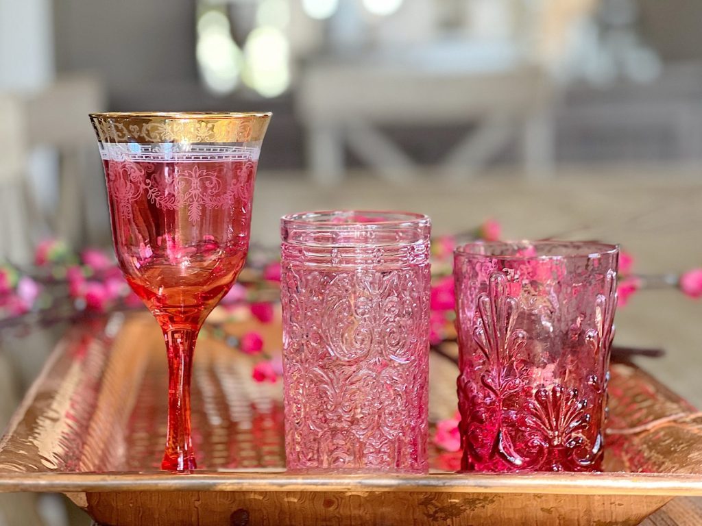 three pink glasses, one with a gold rim, one with texture and one that is original cranberry glass.