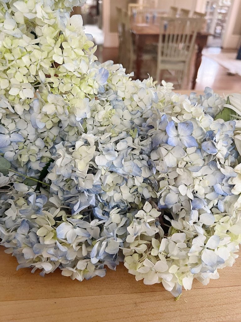 White and light blue hydrangeas layingon a counter.