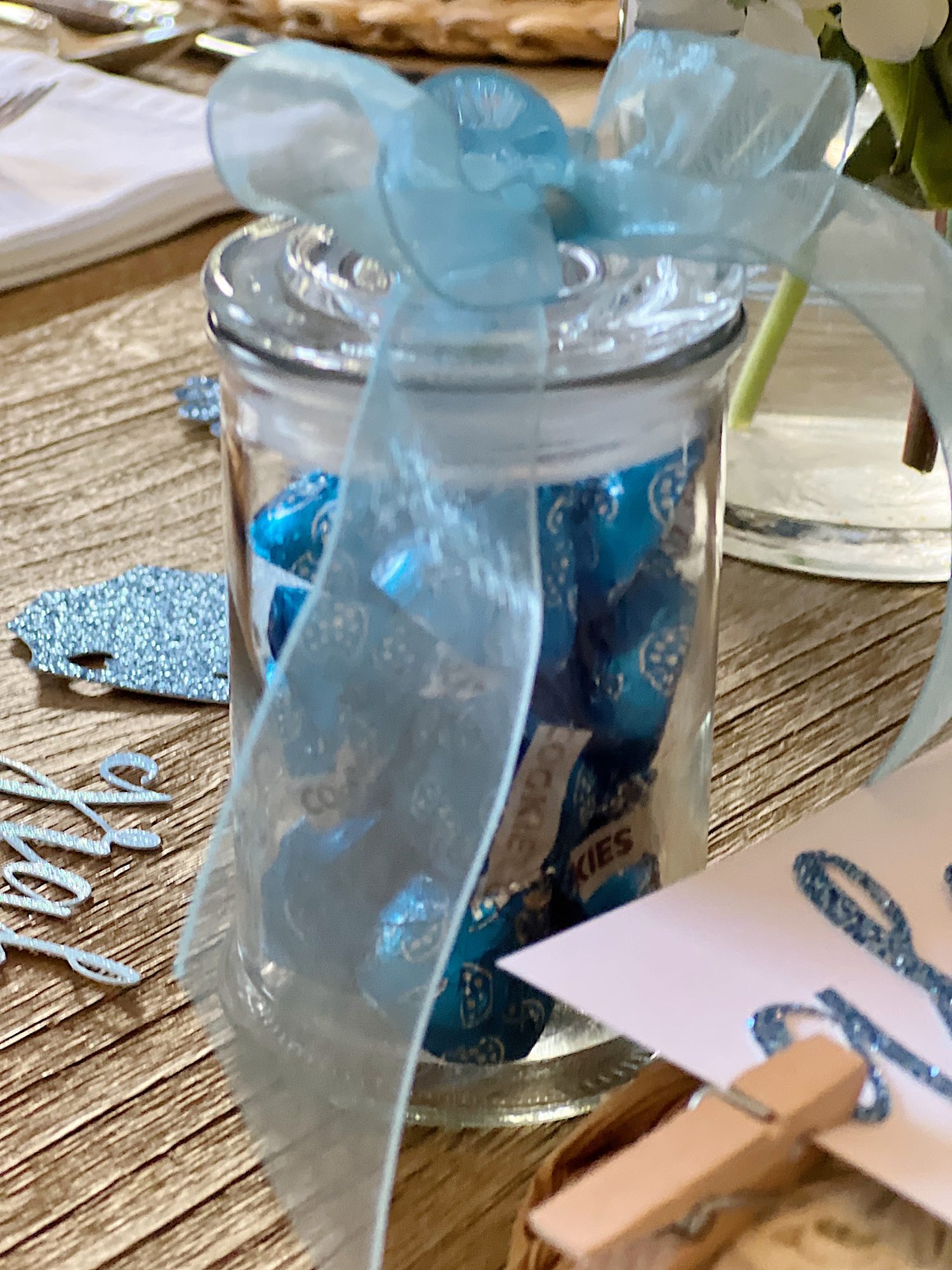 Dining table for a baby shower with blue and white plates, flowers, and babythemed decorations.