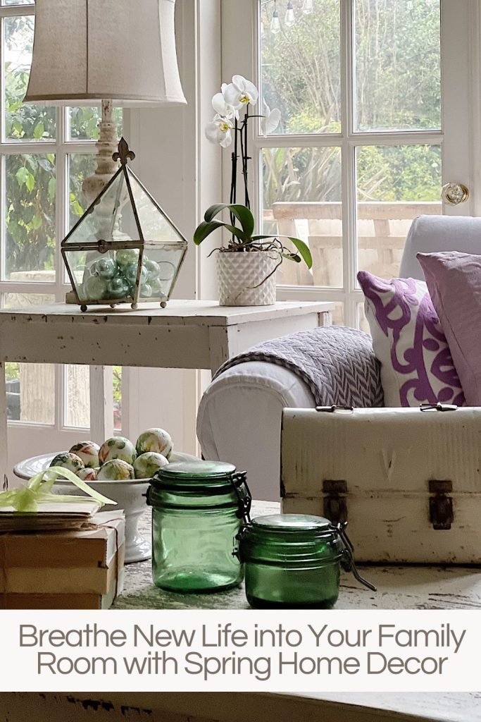 New spring home decor in the family room with lavender throws and pillows and sage green jars, a wreath and small decor items.