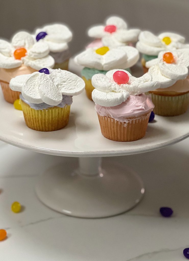 Spring colored cupcakes topped with a cut marshmallow and single jelly bean.