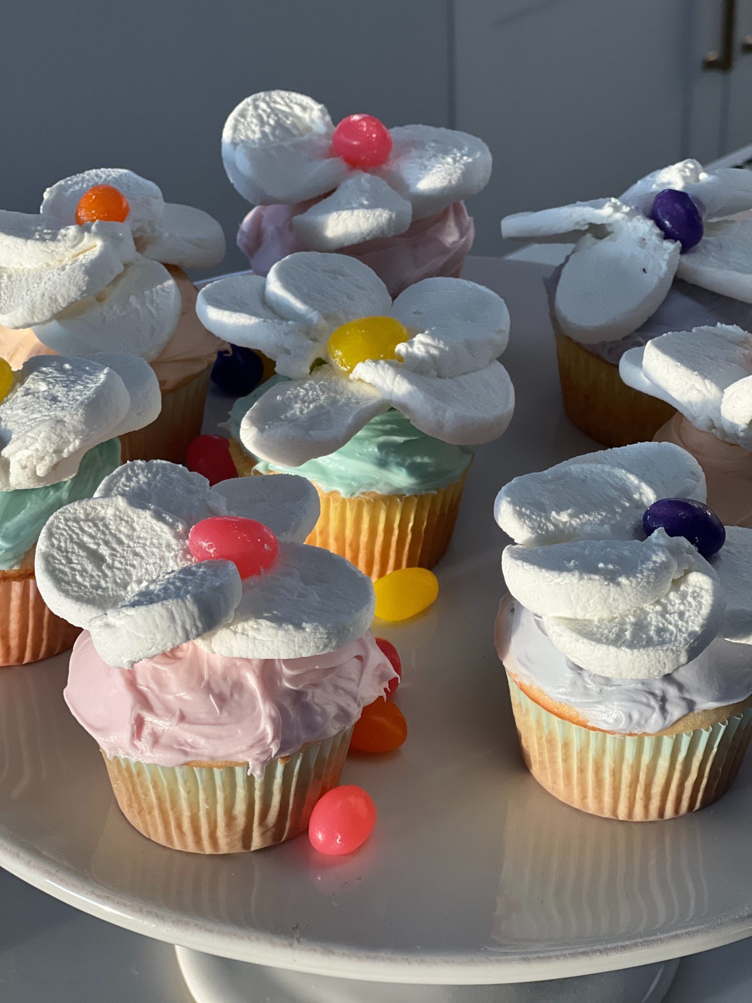 Spring colored cupcakes topped with a cut marshmallow and single jelly bean.