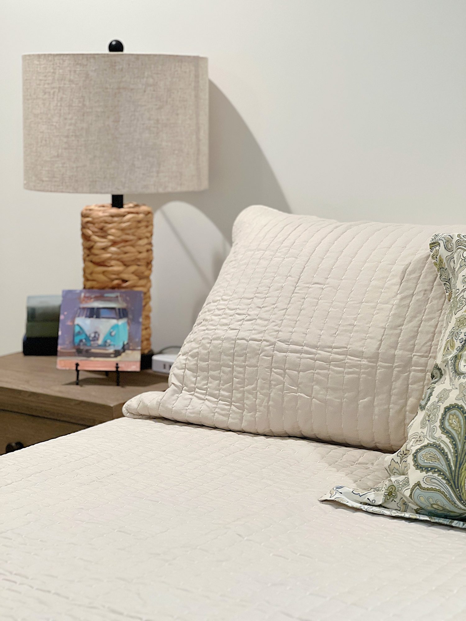 A bedroom with two built in queen sized bunk beds, a king sized bed, rocking chair and green, tan, and blue decor.