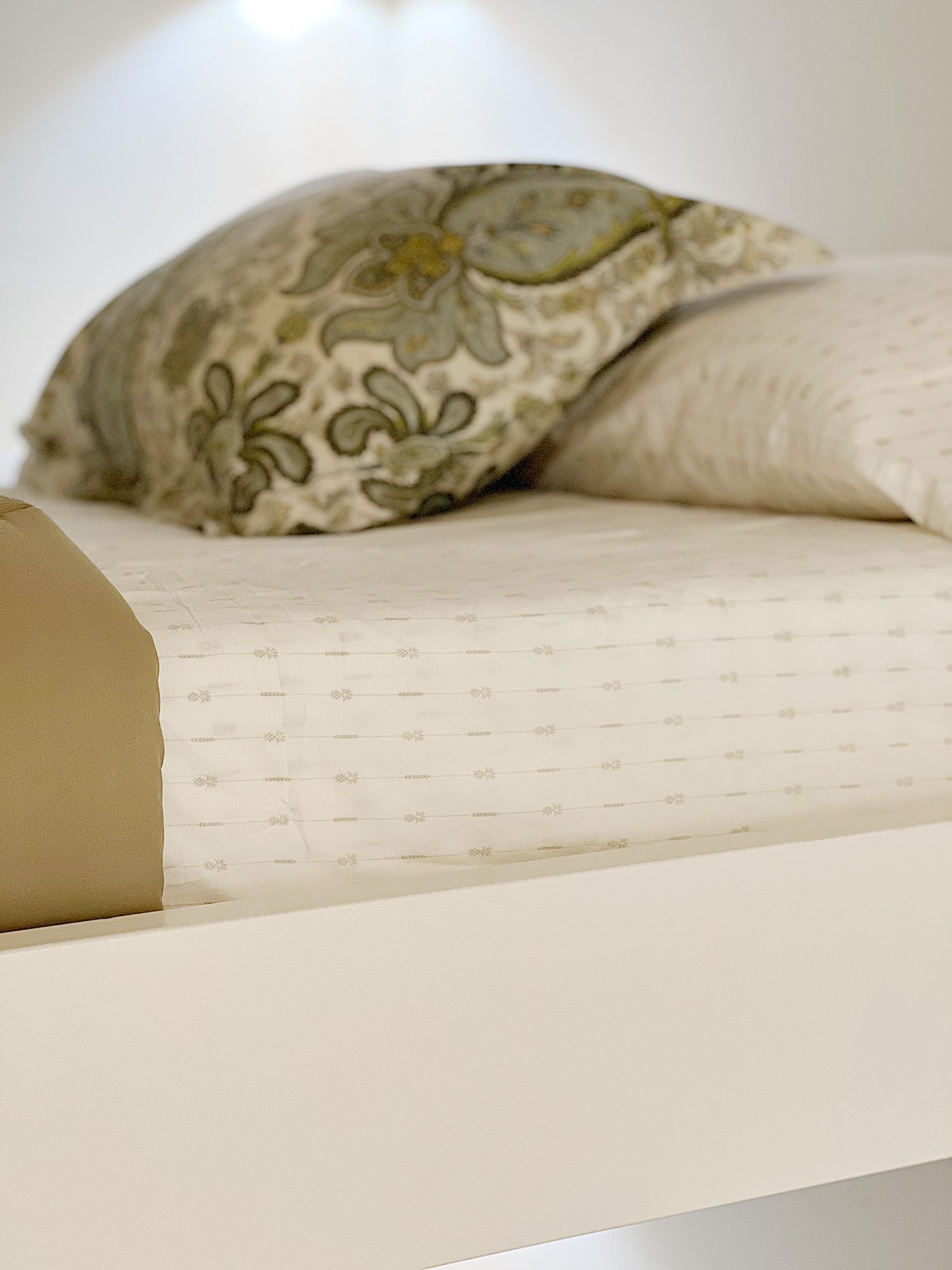 Close up of green and white pineapple decorated sheets from Tommy Bahama on the bunk bed.