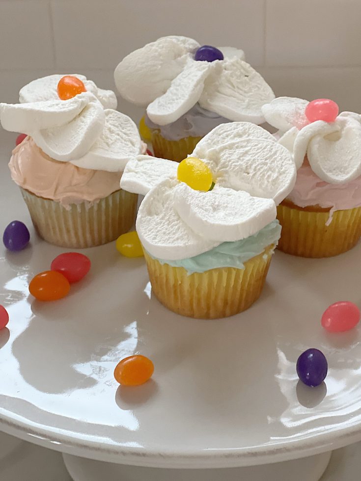 Spring colored cupcakes topped with a cut marshmallow and single jelly bean.