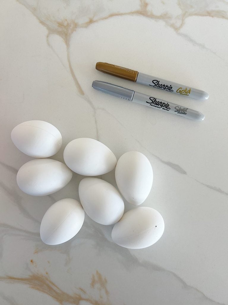 White plastic Easter eggs and a copper sharpie pen