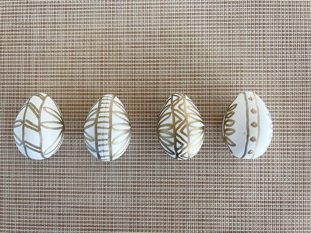 White plastic Easter eggs painted with a copper sharpie pen