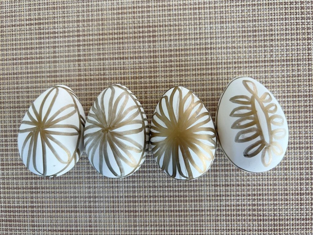 White plastic Easter eggs painted with a copper sharpie pen