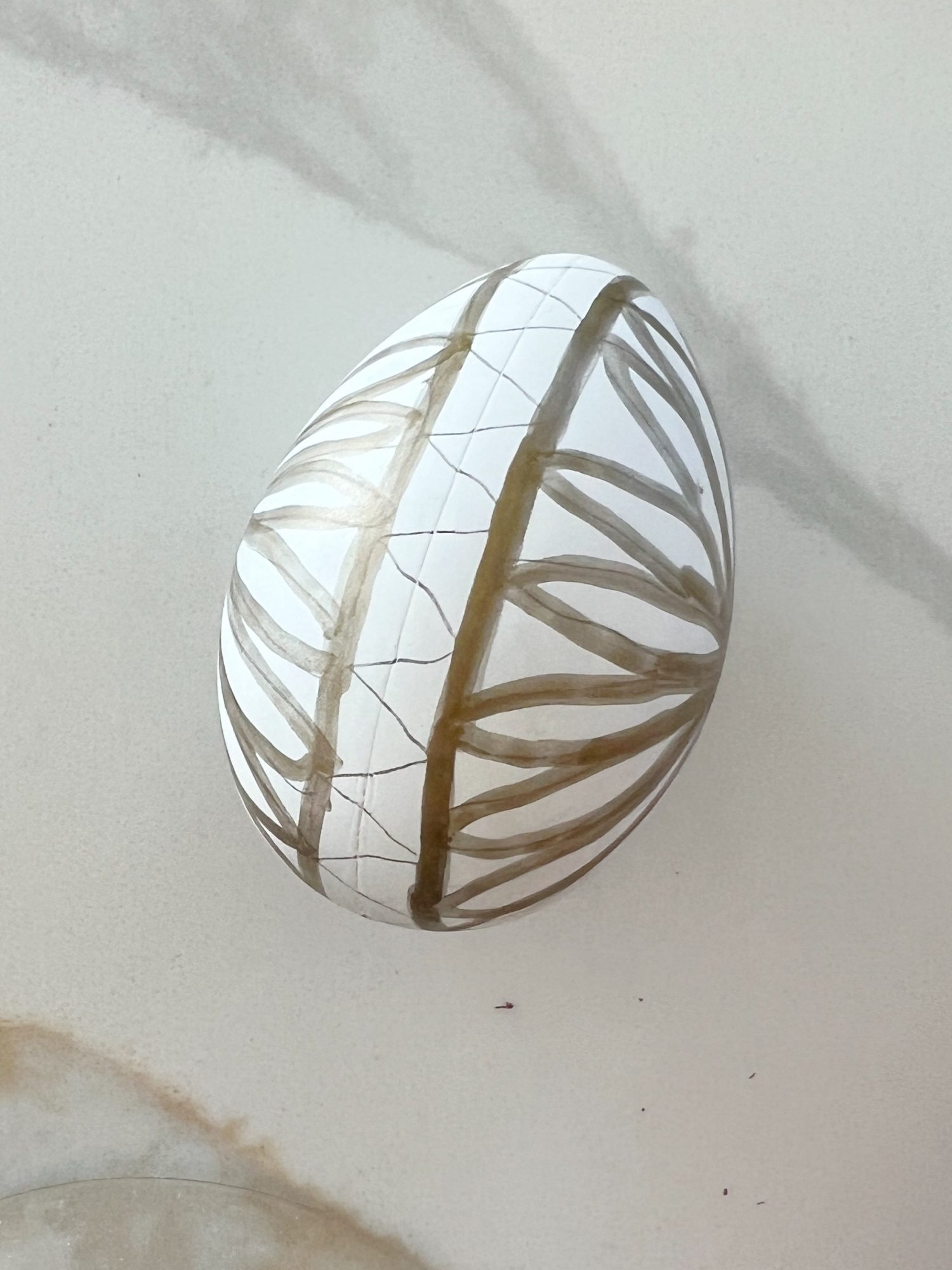 White plastic Easter eggs painted with a copper sharpie pen