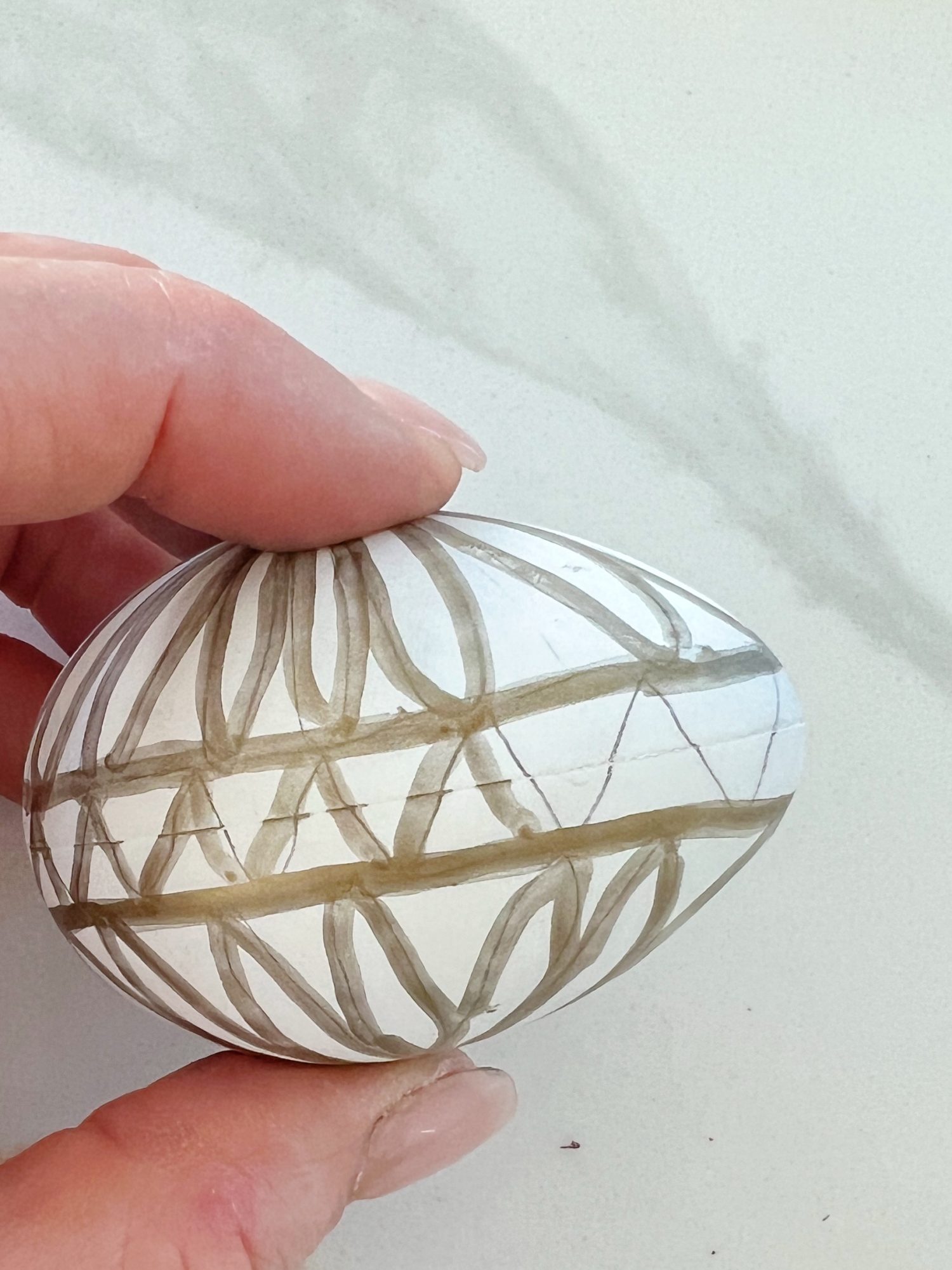 White plastic Easter eggs painted with a copper sharpie pen