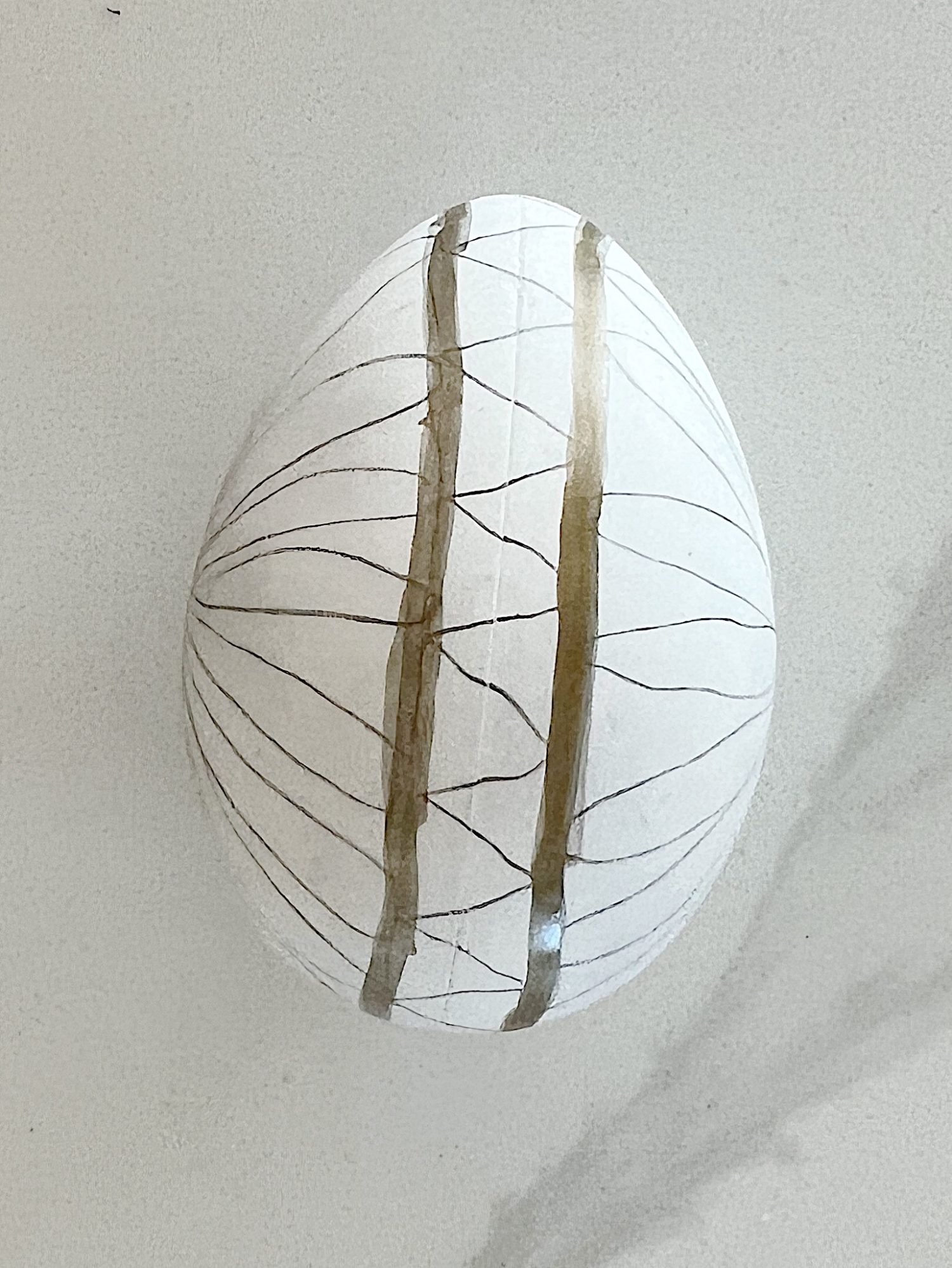 White plastic Easter eggs painted with a copper sharpie pen