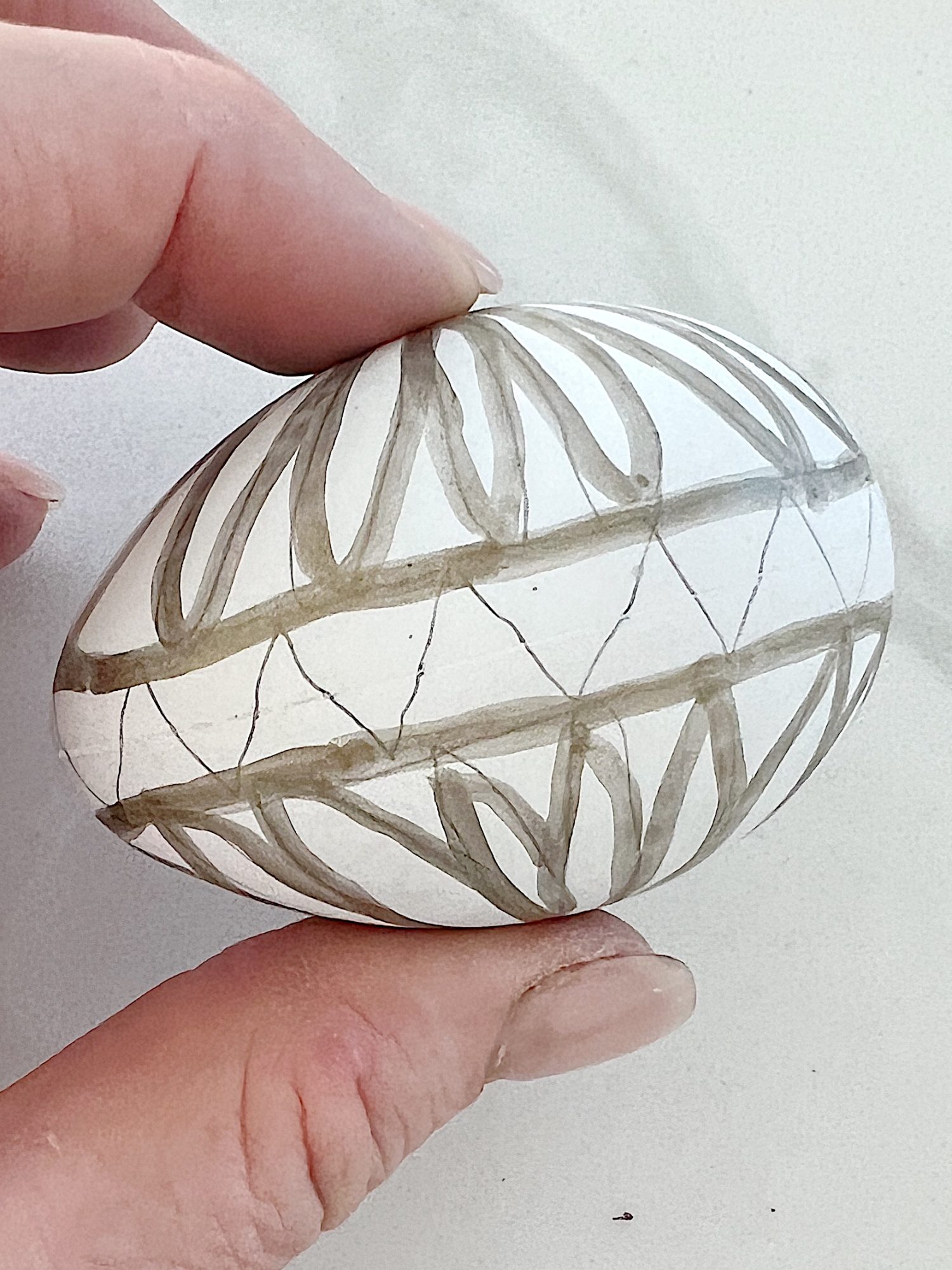 White plastic Easter eggs painted with a copper sharpie pen