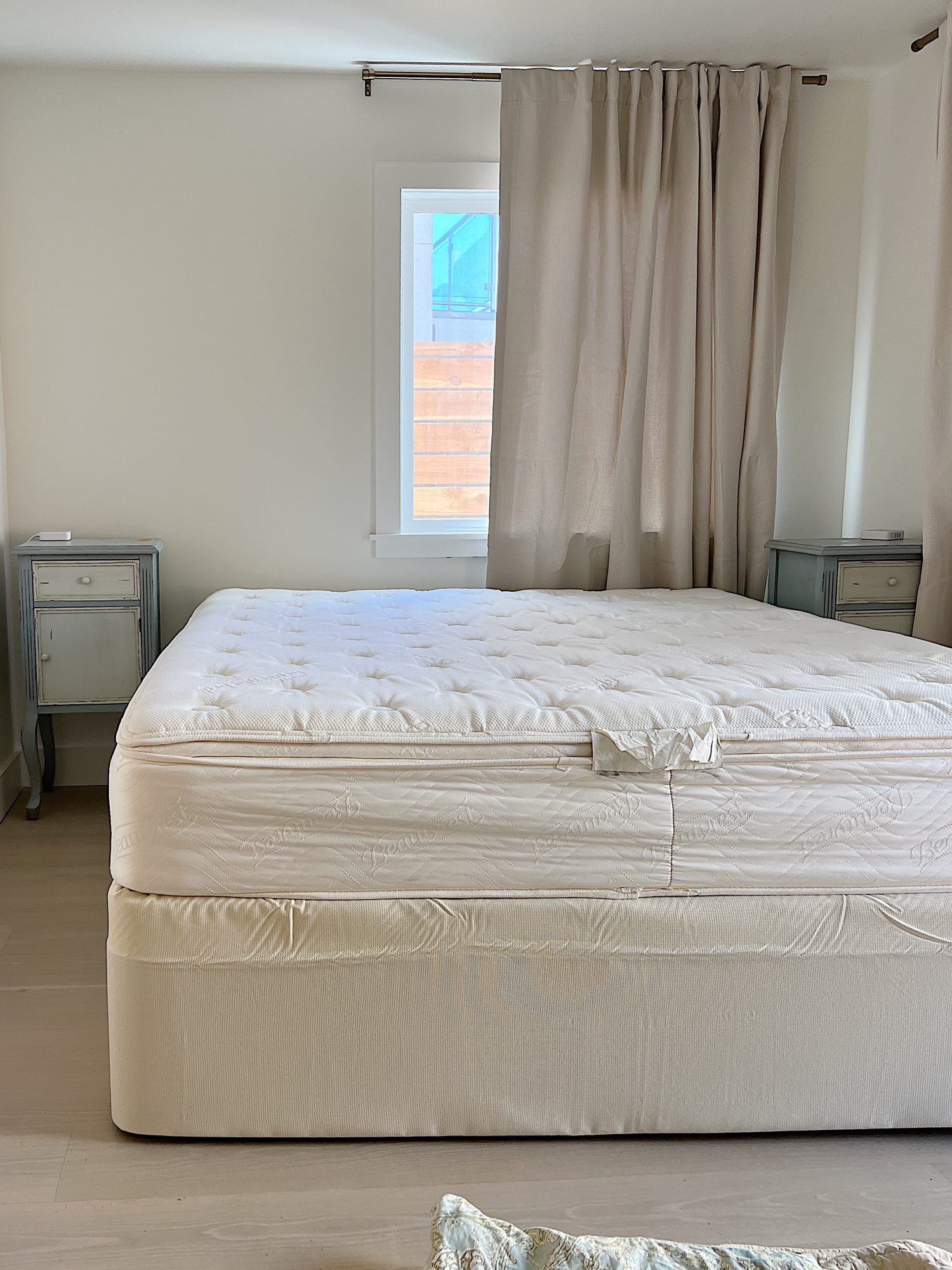 bedrom with drapes, king bed, and night stands