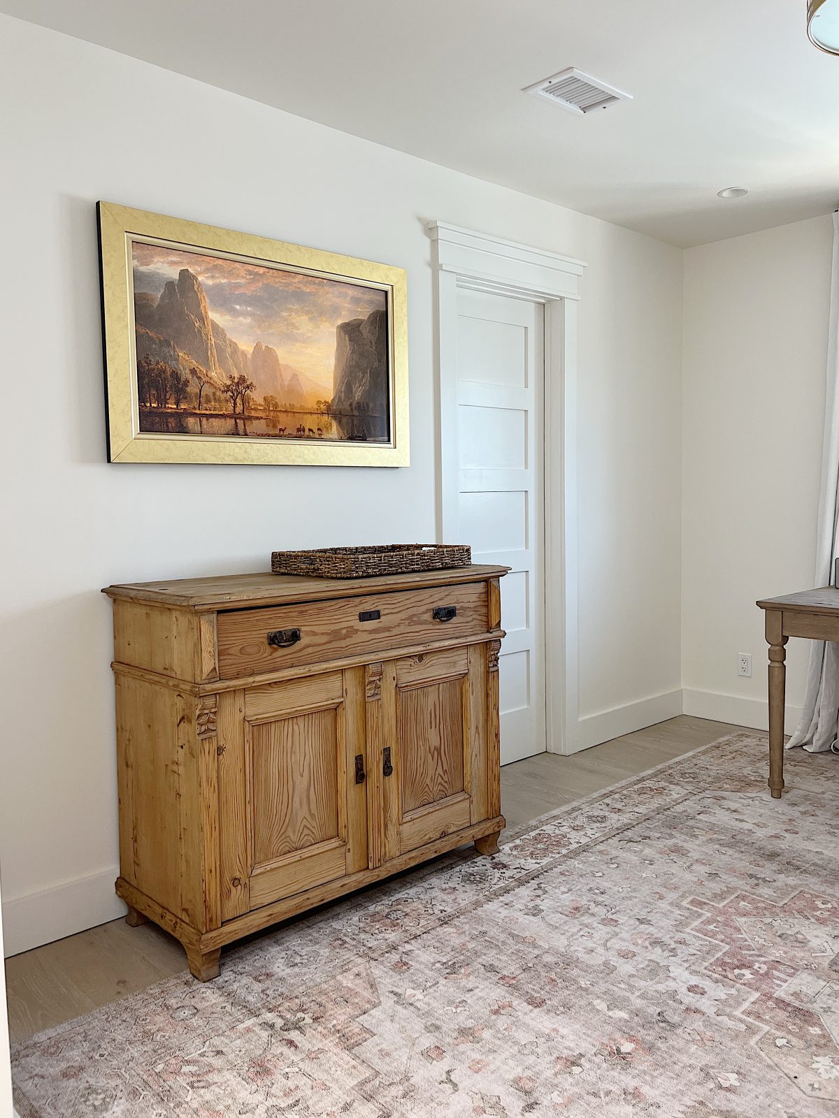 The office at our beach house with a vintage cabinet, a frame tv, and a vintage basket.