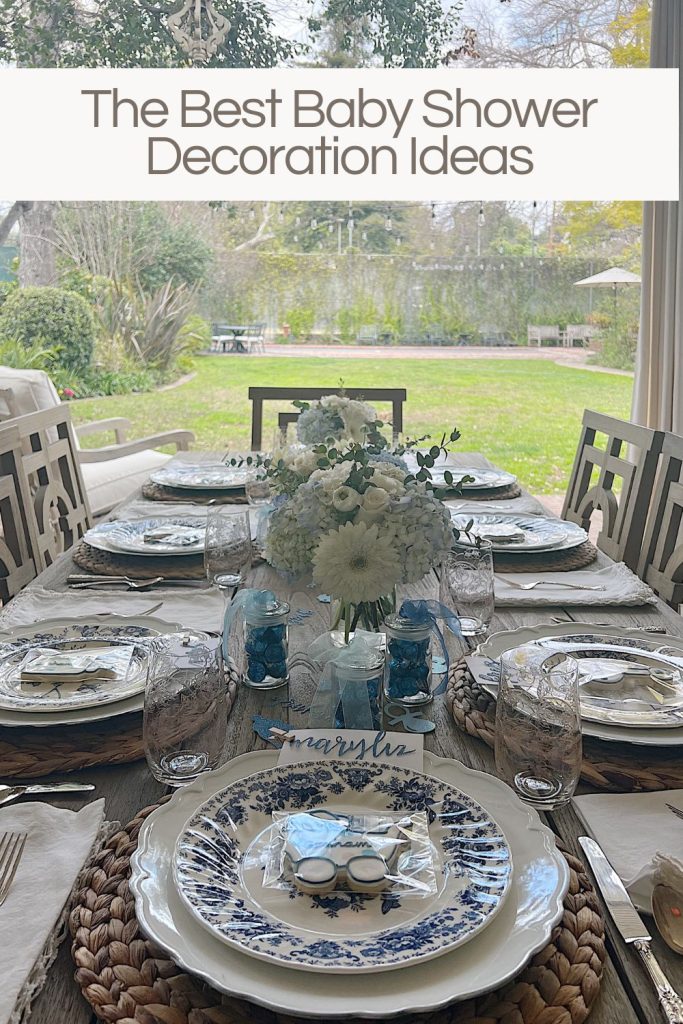Dining table for a baby shower with blue and white plates, flowers, and babythemed decorations.
