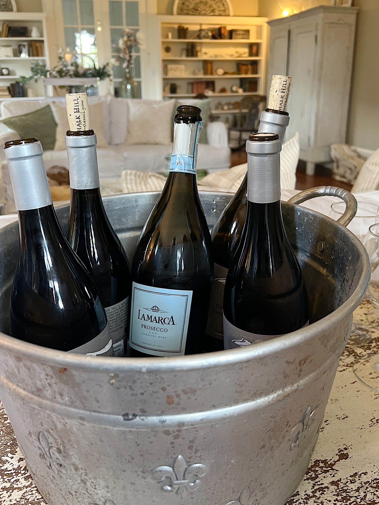 Champagne and wine buttles on ice in a silver bucket.