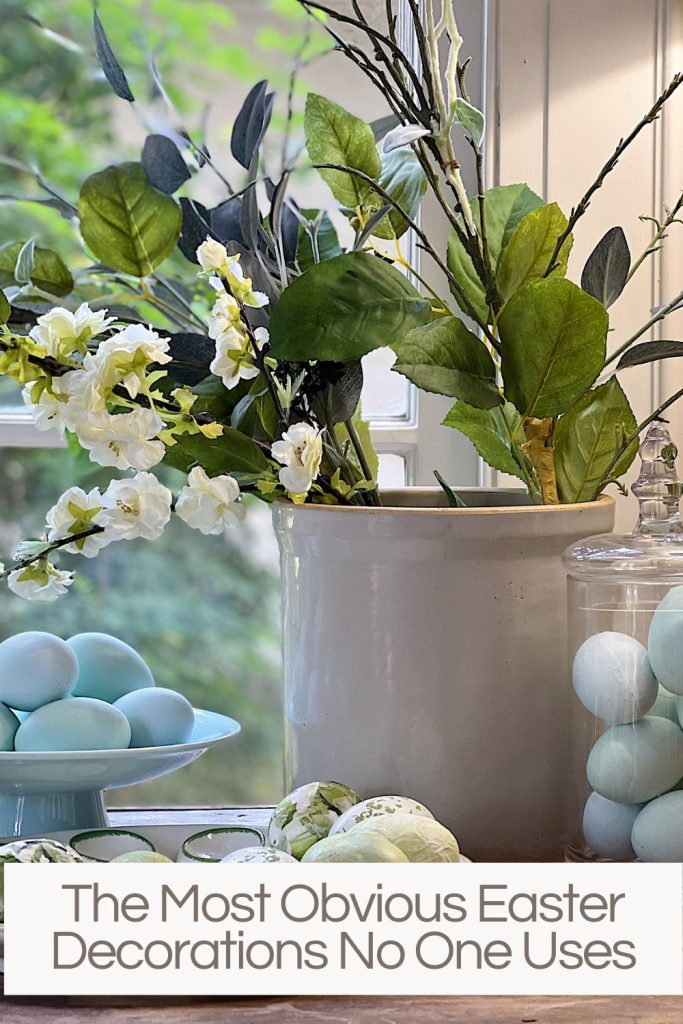 Decorated easter eggs in various containers next to a white crock with faux flowers.
