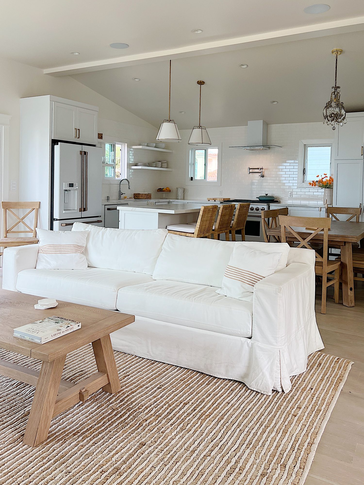 Beach house living room with farmhouse style furniture and large fireplace and frame tv.