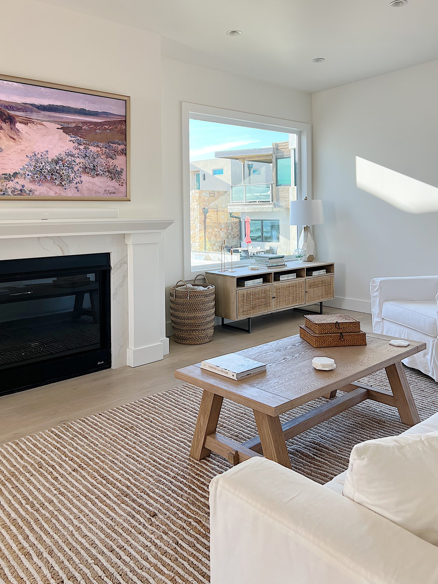 Beach house living room with farmhouse style furniture and large fireplace and frame tv.