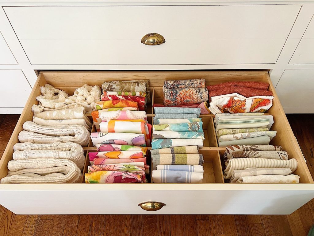 Colorful spring pillow covers in a drawer.