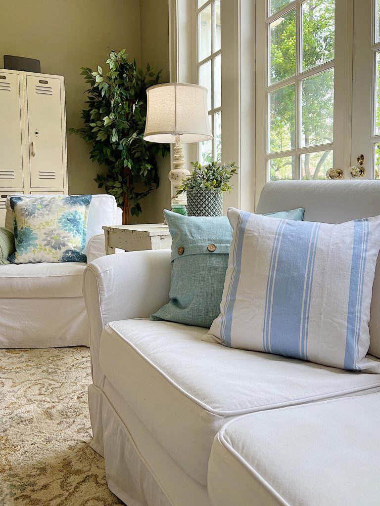 Blue and White spring pillows on the white couch and chair.
