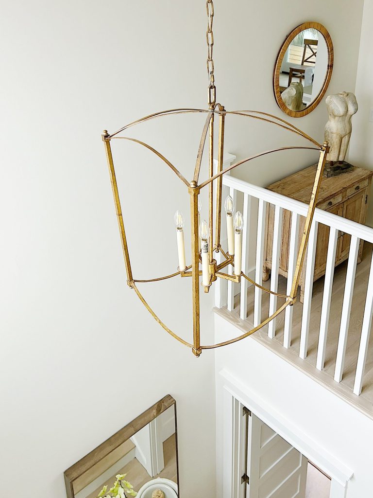 A gold chandelier in the entryway of our beach house.