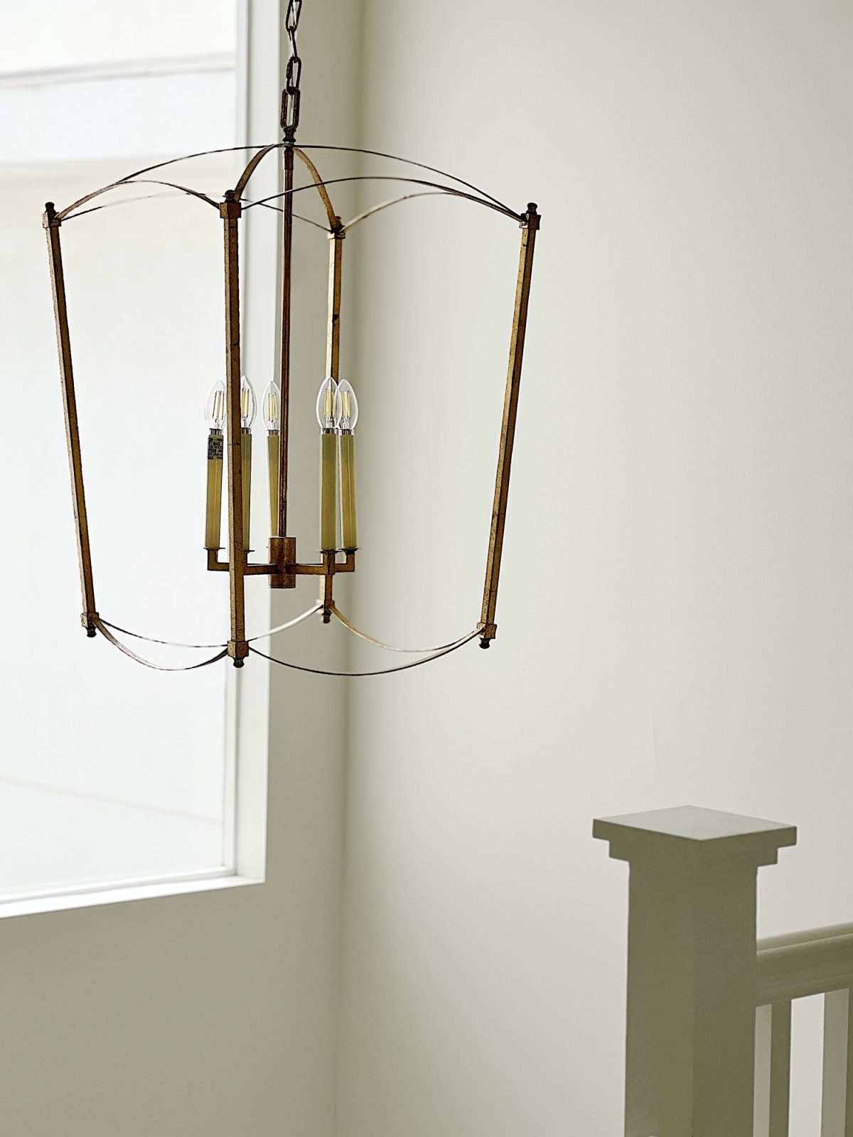 A gold chandelier in the entryway of our beach house.