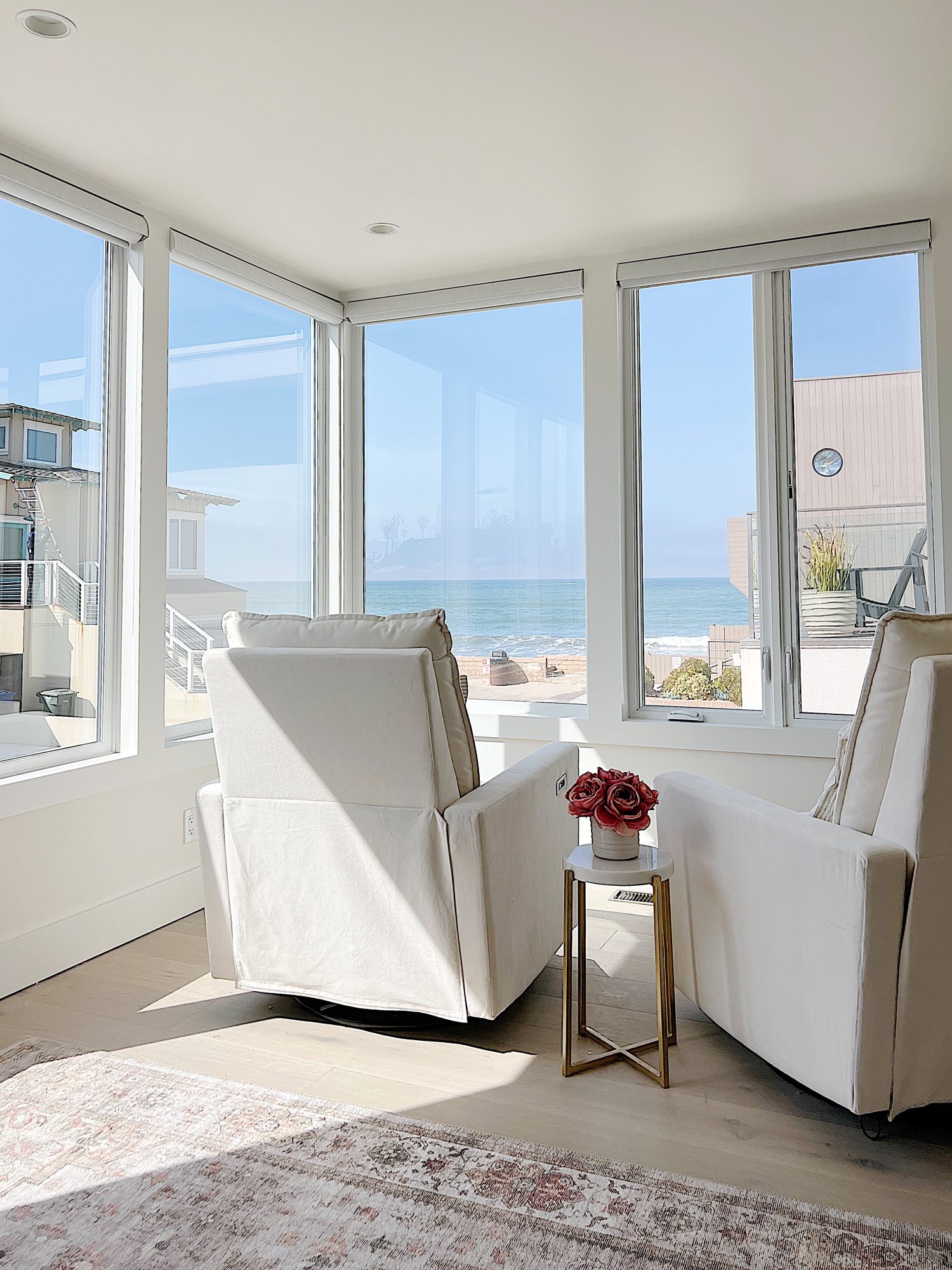 The primary bedroom in our beach house with five windows and an ocean view.