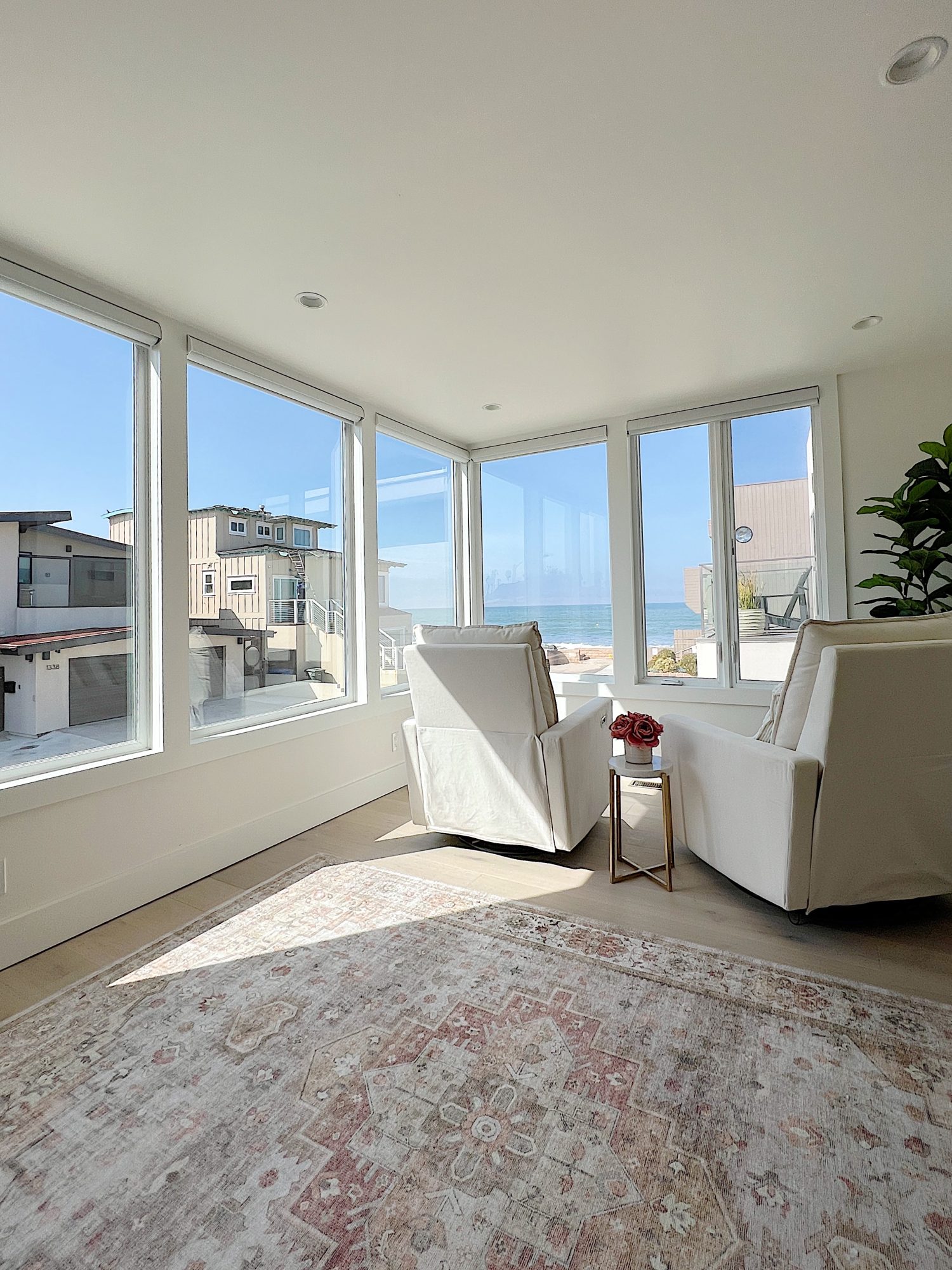 The primary bedroom in our beach house with five windows and an ocean view.
