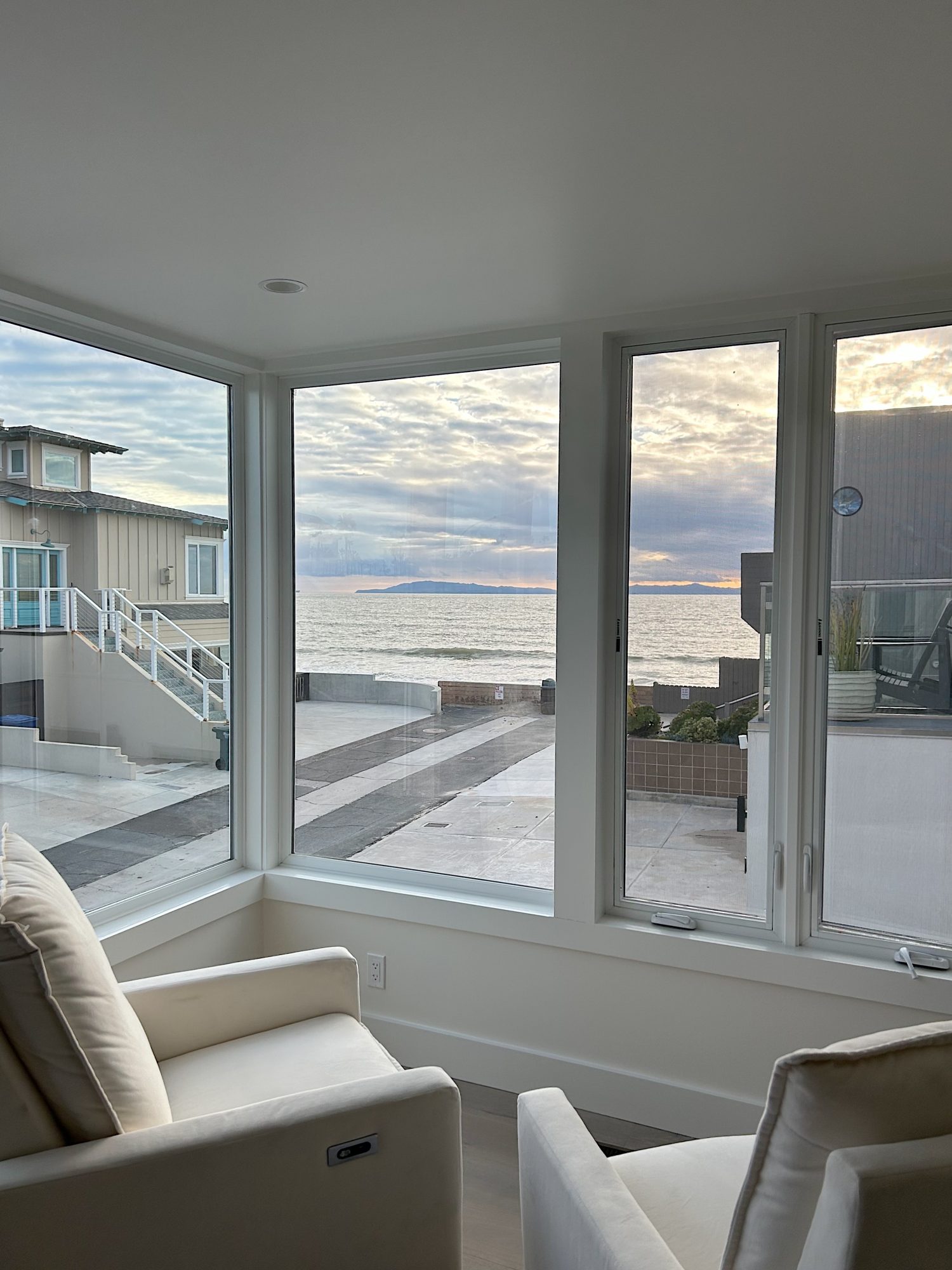 The primary bedroom in our beach house with five windows and an ocean view.
