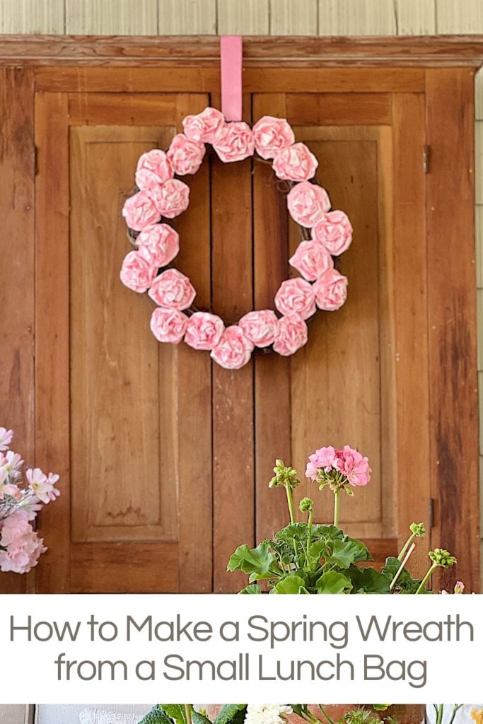 A pink wreath hanging on an armoire made from pink paper lunch bags.