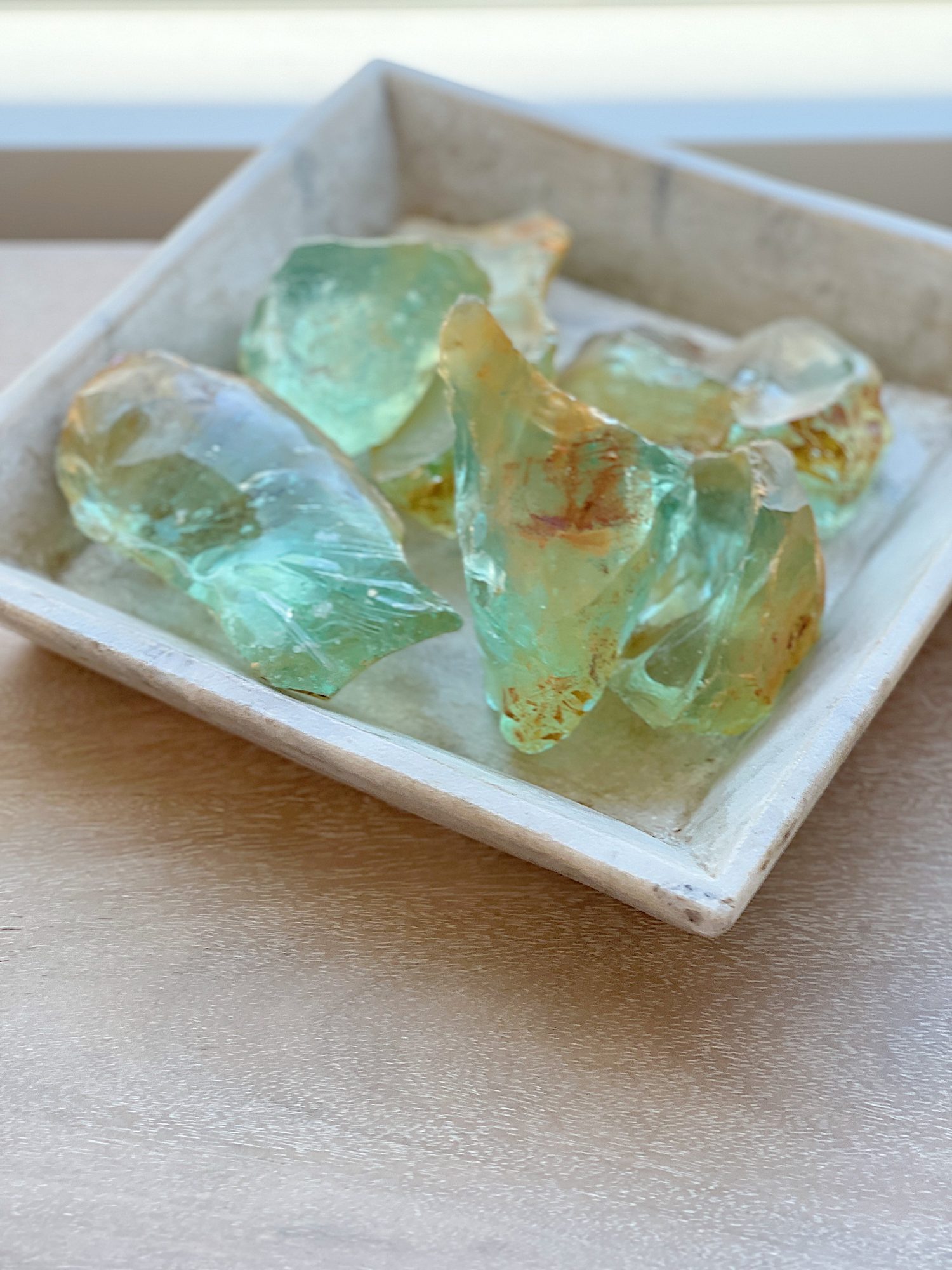 A vintage marble container filled with old glass from a windshield factory next to a new gold lamp.