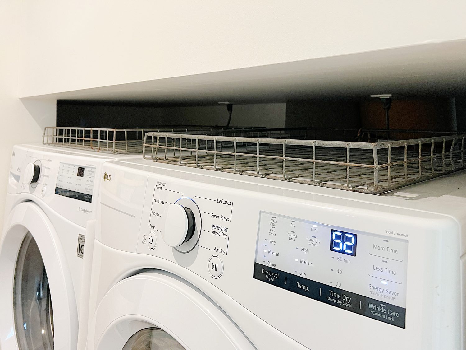 Two wire baskets sitting on top of a washer and dryer.