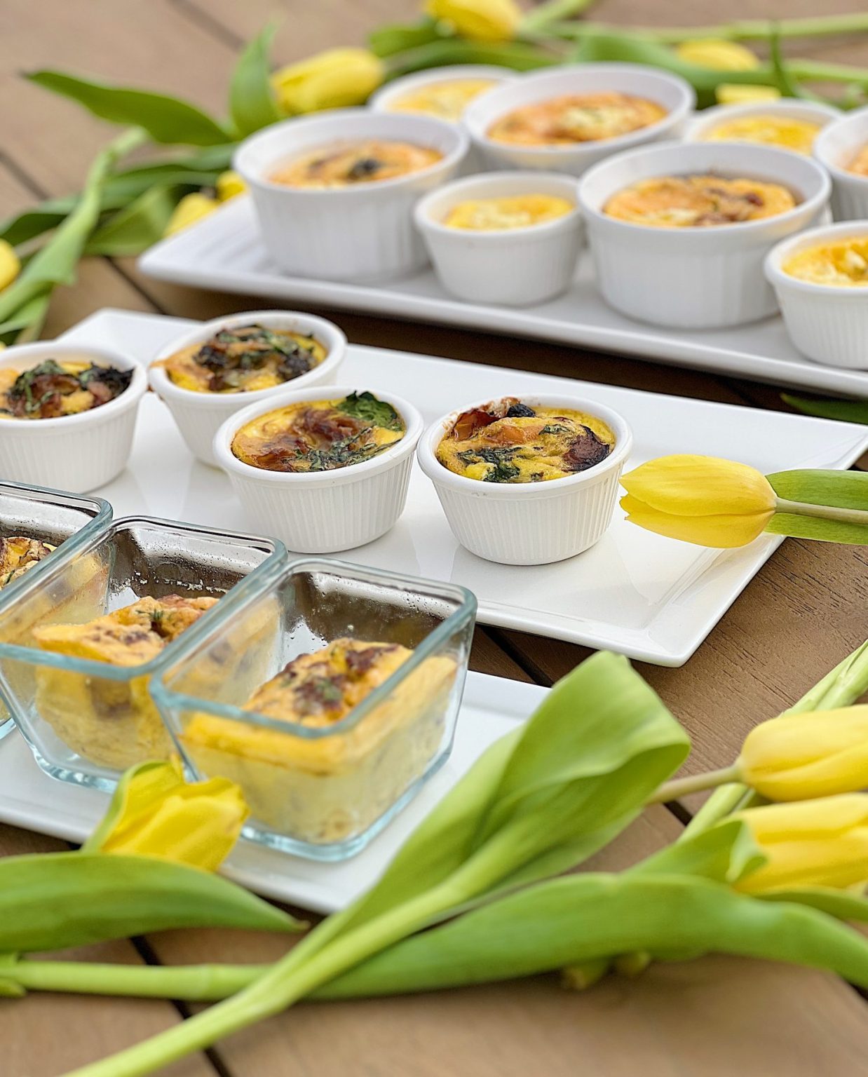 A Mother's Day Brunch buffet with four different kinds of egg bites and some pretty yellow tulips.