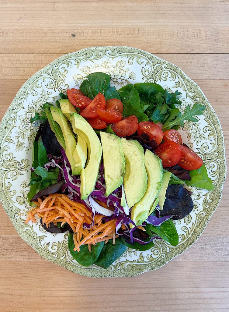 Spring Salad Recipe with Spice-Rubbed Salmon, mixed greens, tomatoes, avocados, cabbage, carrots, corn, and cilantro dressing.