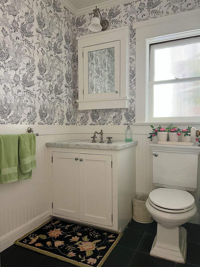 Black and white wallpaper in a white bathroom.