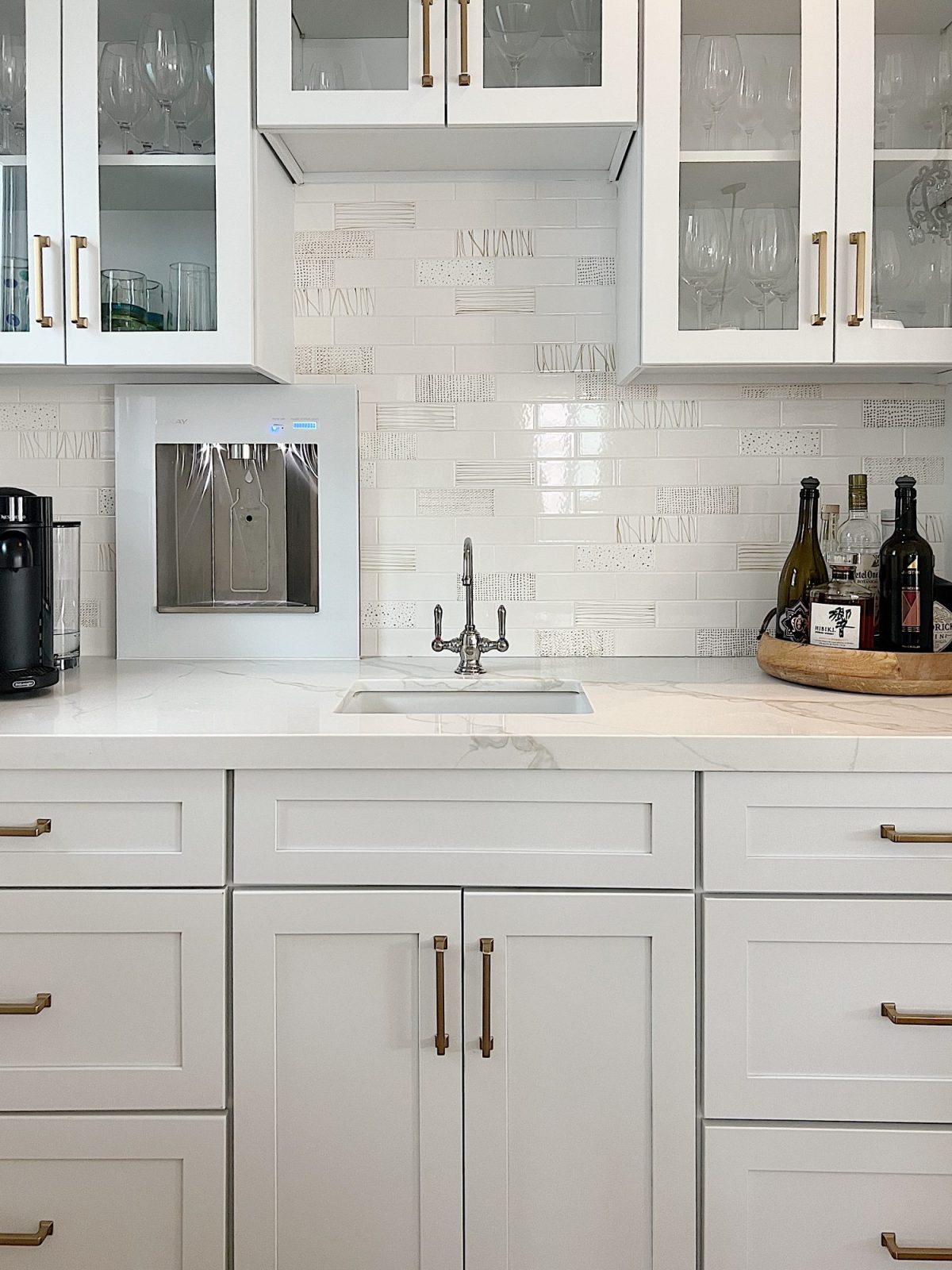 The finished beach house kitcehn with white cabinets, countertops, appliances, and an island.