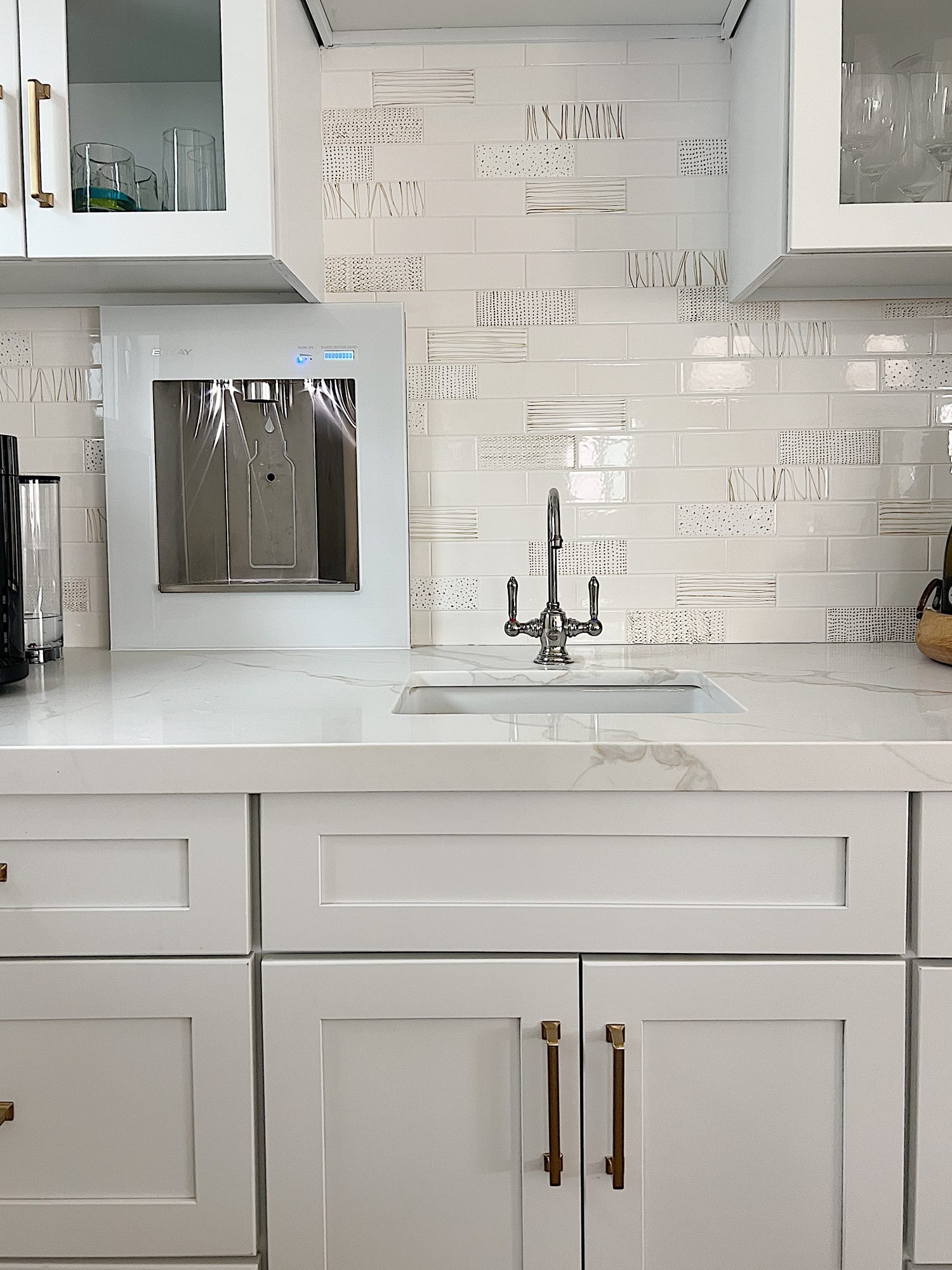 The finished beach house kitcehn with white cabinets, countertops, appliances, and an island.