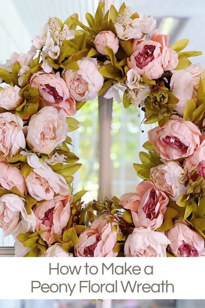 A handmade wreath with pink faux peonies.