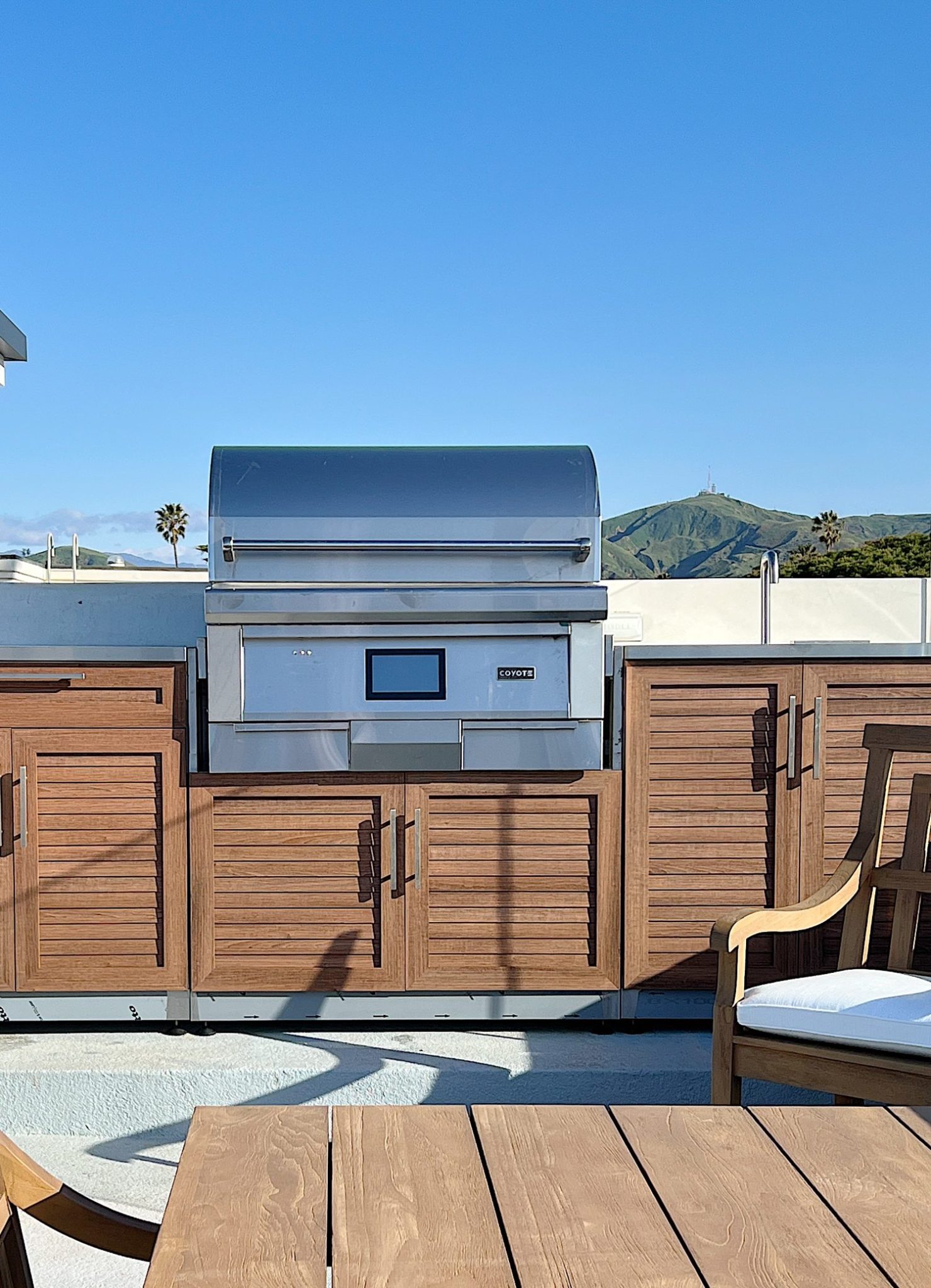 An outdoor kitchen with a Coyote pellet grill.
