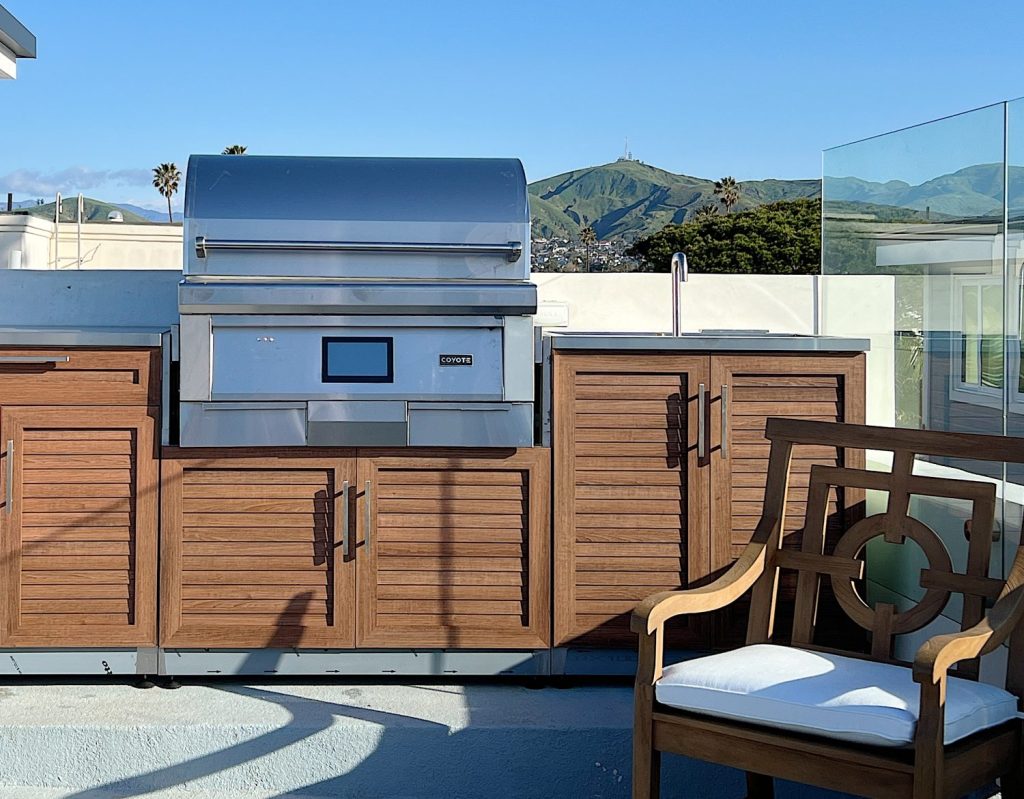An outdoor kitchen with a Coyote pellet grill.