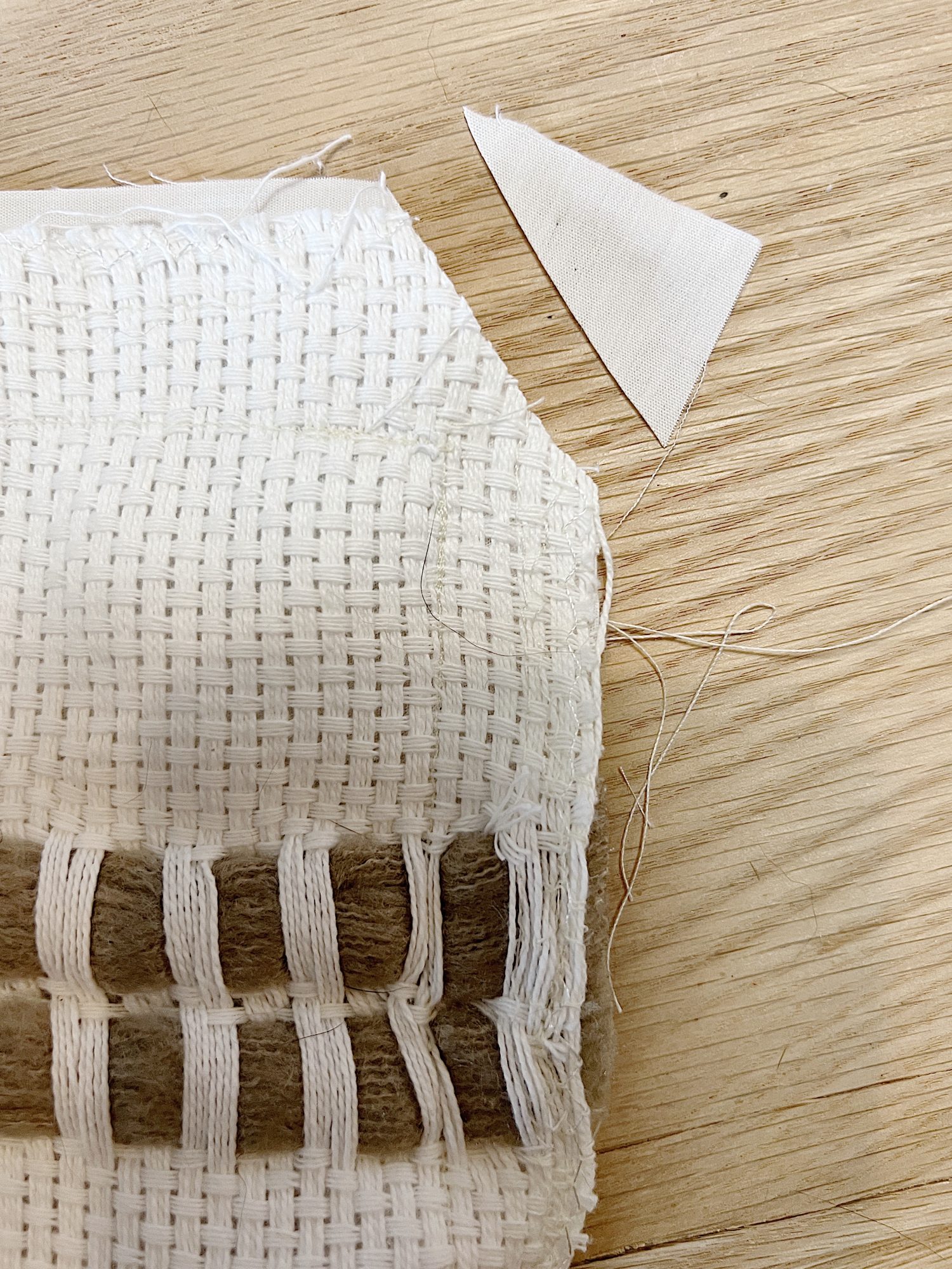 Handmade monk cloth pillow with yarn being constructed.
