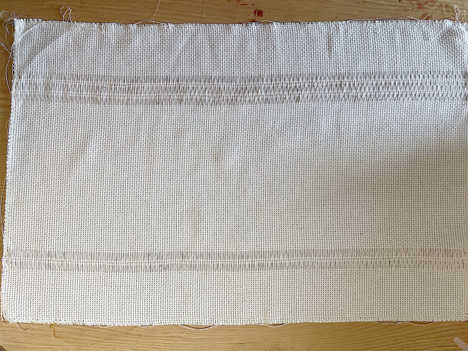 Handmade monk cloth pillow with yarn being constructed.
