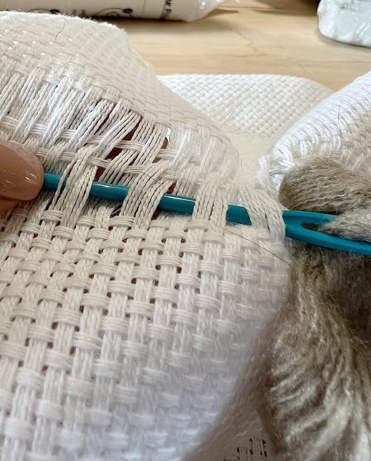 Handmade monk cloth pillow with yarn being constructed.