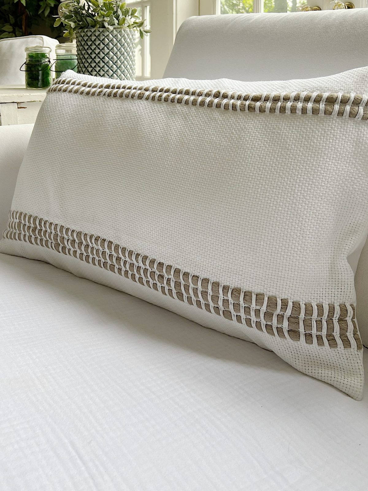 Handmade monk cloth pillow with yarn sitting on top of a couch.