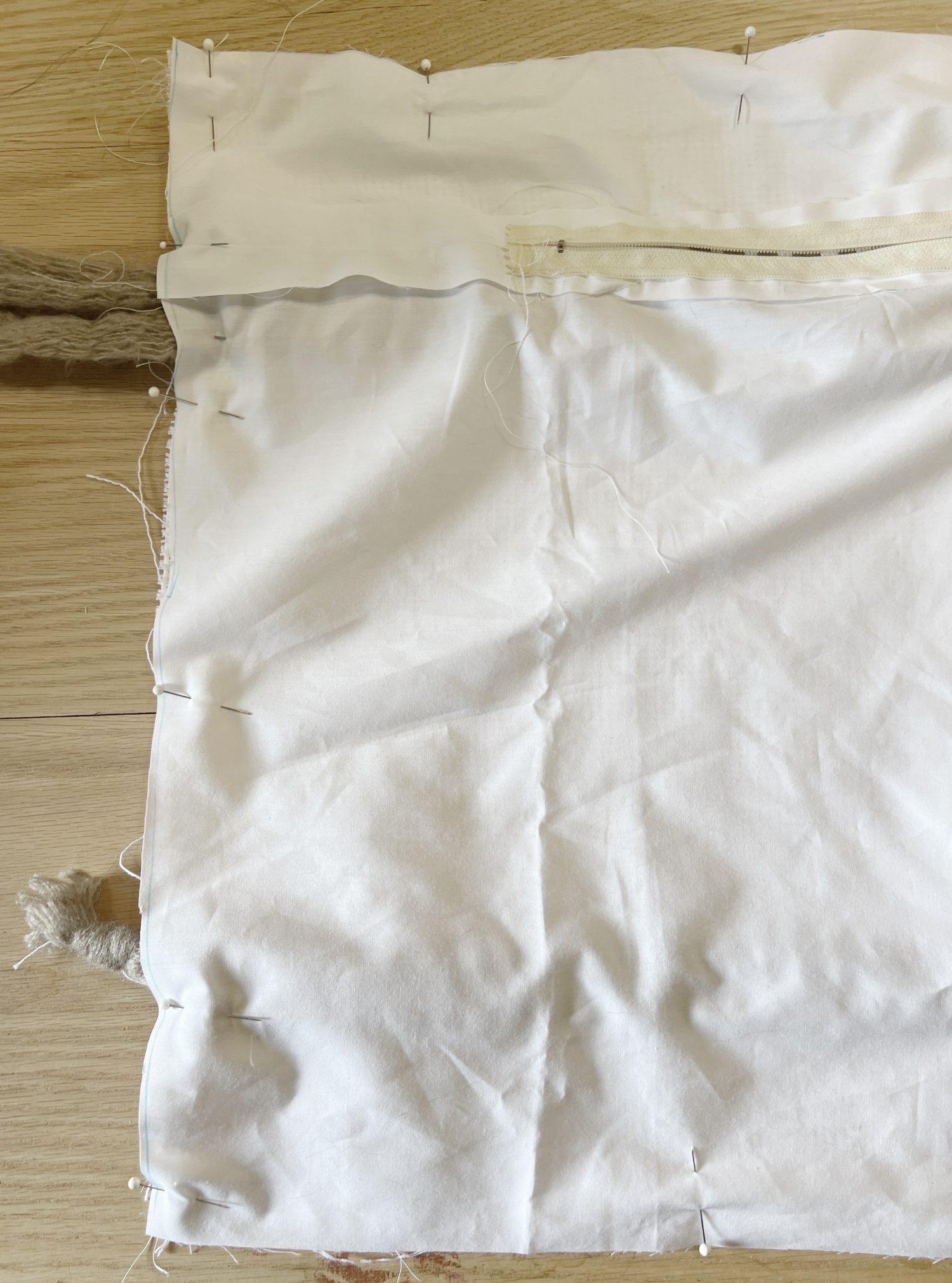 Handmade monk cloth pillow with yarn being constructed.